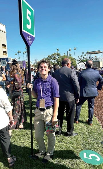 Student holding Breeders' Cup sign