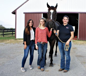 Students stand with horse