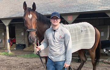 Eric DeCoster standing with a horse