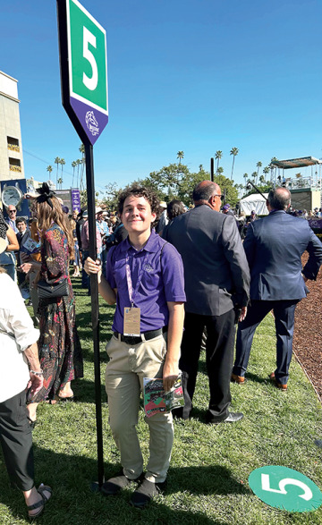 Student holding Breeders' Cup sign
