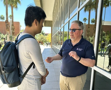 Curtis Linnell speaks to student on campus