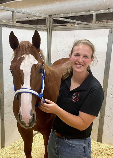 Dr. Abbie Haffner, DVM, standing with a horse